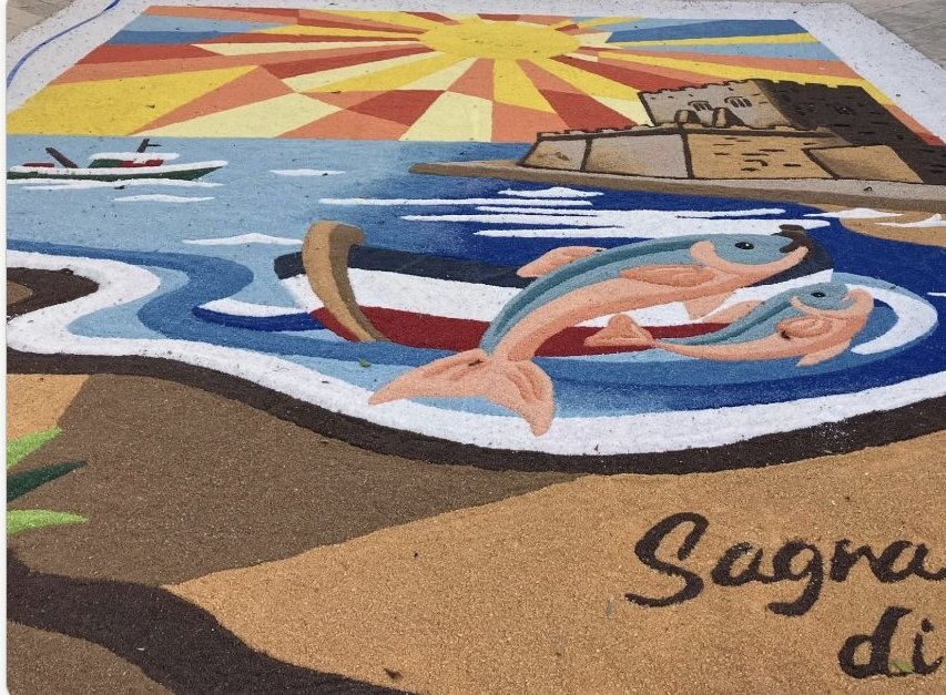 Colourful sand-art street mural for a Sicilian sagra: fishing boat, two fish and a coastal tower under a rising sun